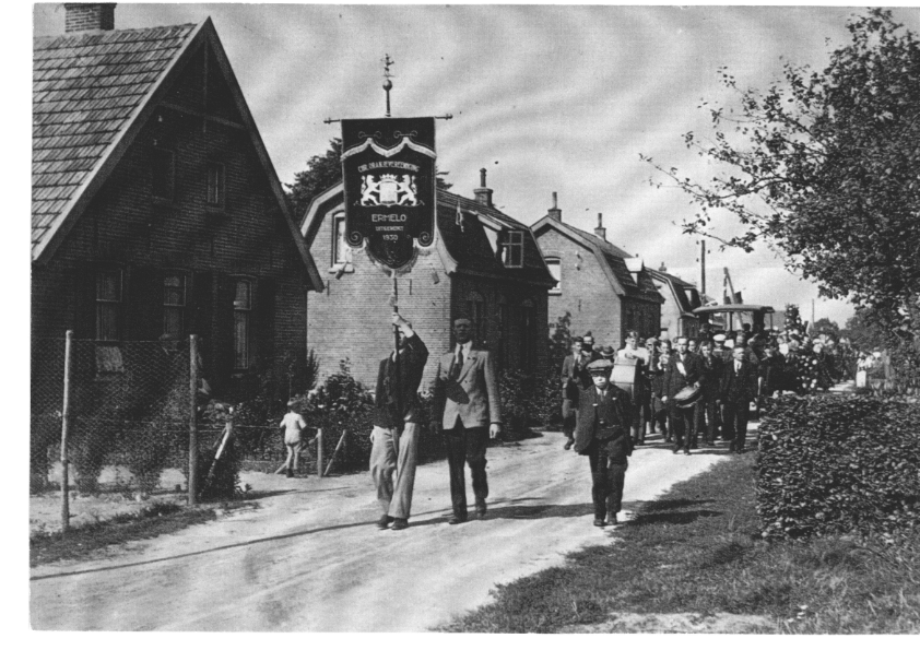 Optocht Oranjevereniging Ermelo met vaandel